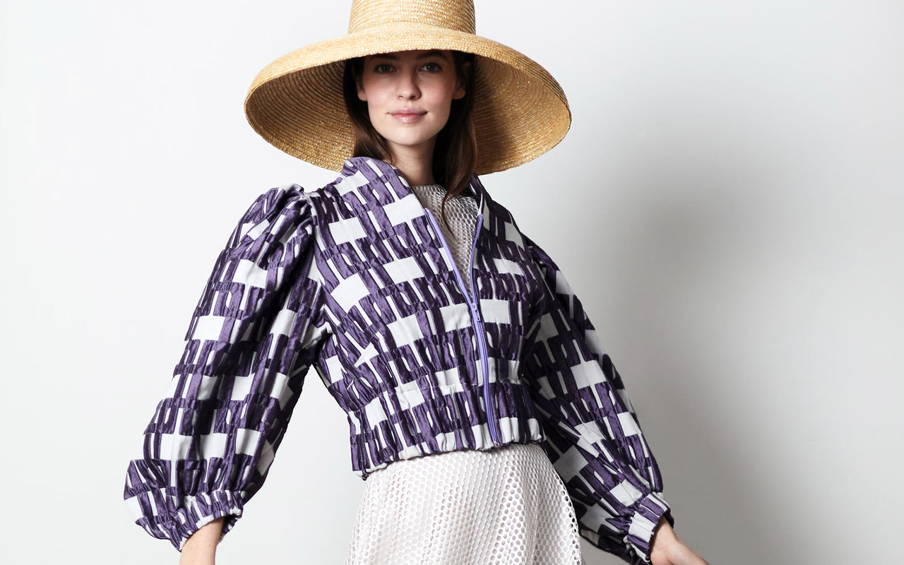 Model mit Strohhut mit kurzer Jacke und Ballon-Ärmeln aus markanten Jacquard-Muster