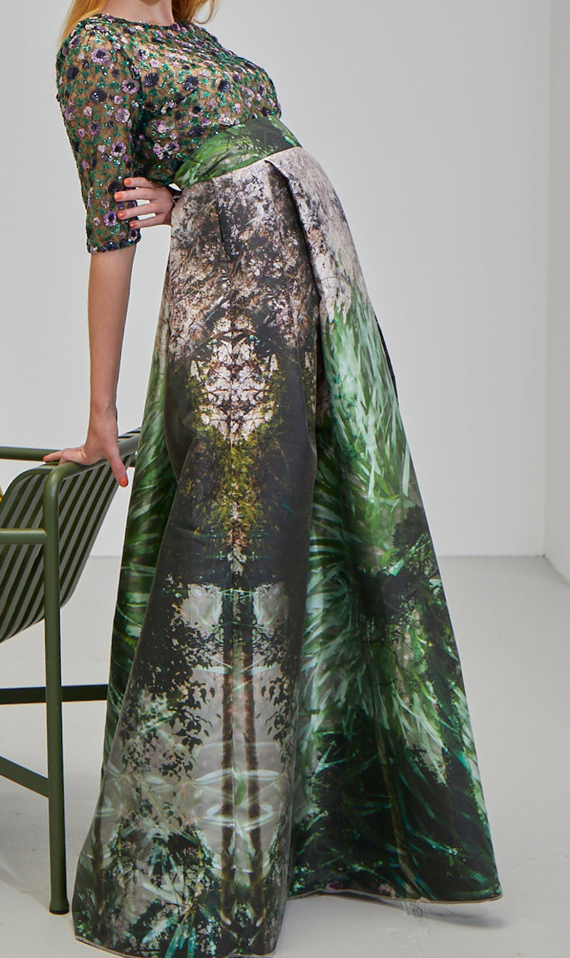Model trägt Faltenrock aus Duchesse mit Motiv Deep Green der Art Edition und ein Blusentop aus violett-grüner Paillettenspitze