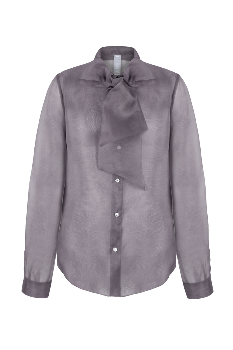 Diese Schluppenbluse in Mauve ist ein zeitloser Klassiker, der je nach Farbton auch ansprechend auffällig wirken kann. Das Modell aus feinem Organza hat eine elegante, sichtbare Knopfleiste und Raffungen an den Manschetten. Die Bluse ist grau, leicht transparent und deshalb perfekt für den Frühling und Sommer. 